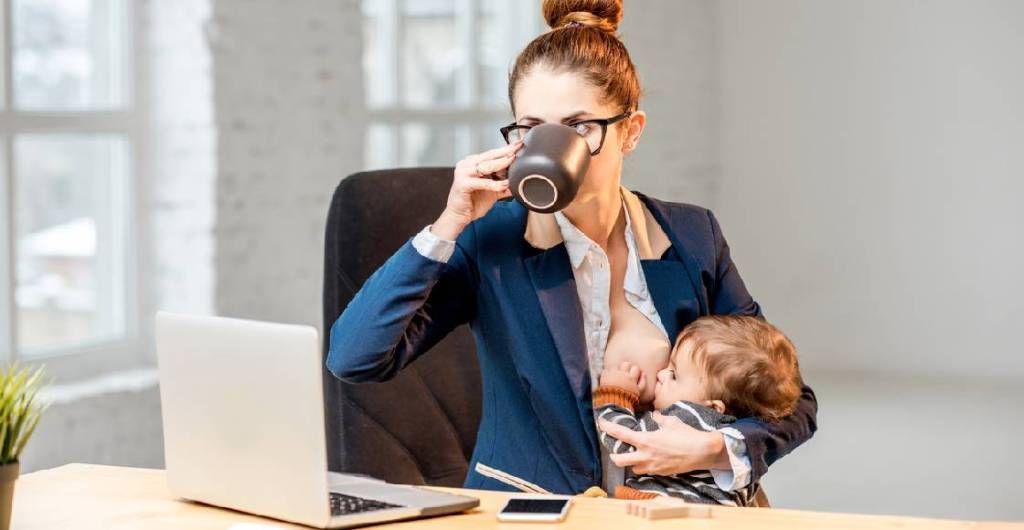 Una mujer alimentando a su bebé en la oficina
